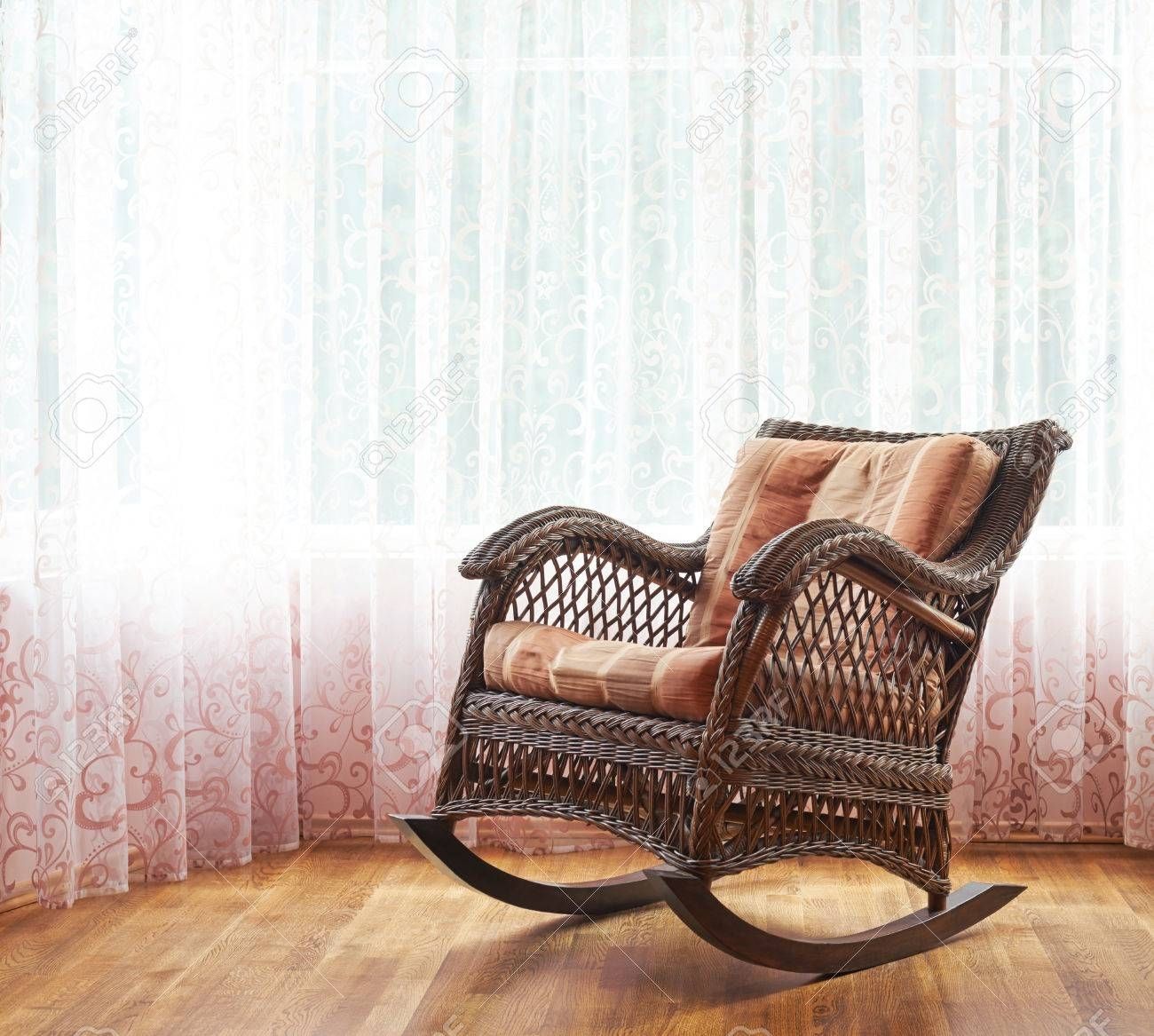 Brown Wicker Rocking Chair Against The Window's Curtains, Indoor Within Indoor Wicker Rocking Chairs (View 15 of 15)